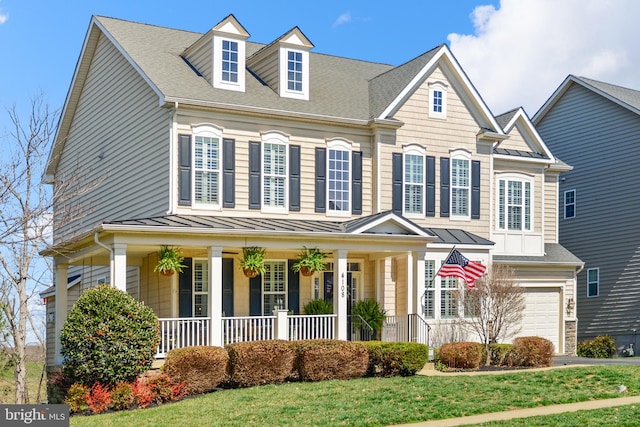 4108 Brushfield Dr, Frederick, MD 21704 - view of front of house featuring a standing seam roof, a porch, an attached garage, a front lawn, and metal roof
