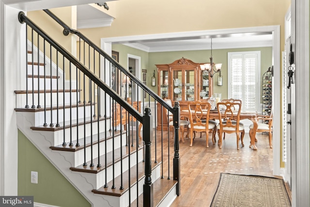 4108 Brushfield Dr, Frederick, MD 21704 - stairway with crown molding, wood finished floors, and a chandelier
