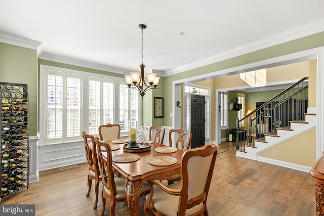 4108 Brushfield Dr, Frederick, MD 21704 - dining space with a chandelier, wood finished floors, ornamental molding, a wainscoted wall, and stairway