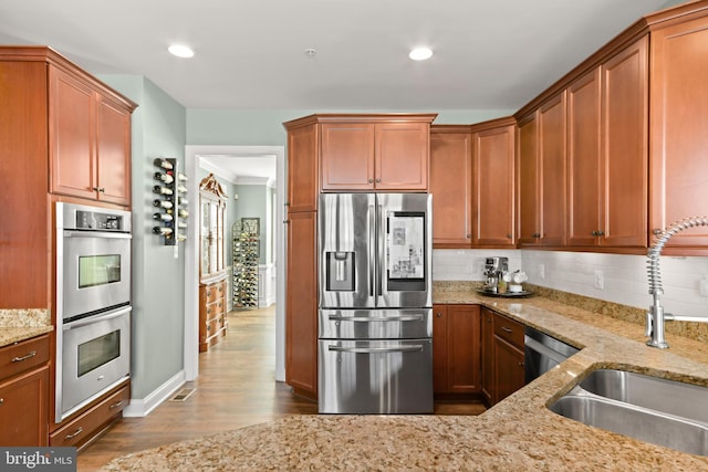 4108 Brushfield Dr, Frederick, MD 21704 - kitchen featuring stainless steel appliances, a sink, dark wood-style floors, backsplash, and light stone countertops