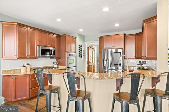 4108 Brushfield Dr, Frederick, MD 21704 - kitchen with stainless steel appliances, tasteful backsplash, a peninsula, light stone counters, and recessed lighting