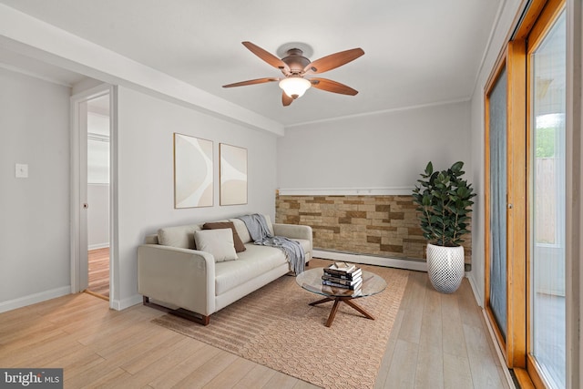 living room featuring a baseboard radiator, a ceiling fan, light wood-type flooring, and baseboards
