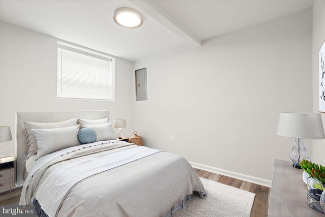 bedroom with wood finished floors, electric panel, baseboards, and beamed ceiling