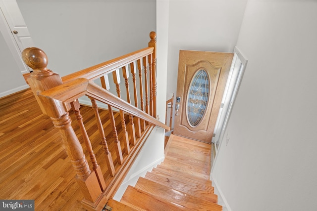 stairs featuring wood finished floors and baseboards