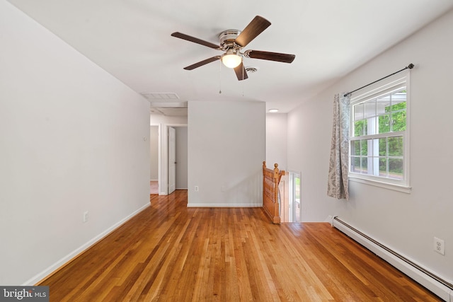 unfurnished room with baseboard heating, light wood-style flooring, baseboards, and ceiling fan