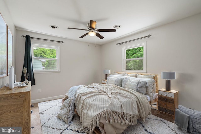 bedroom with multiple windows, carpet floors, baseboards, and a ceiling fan