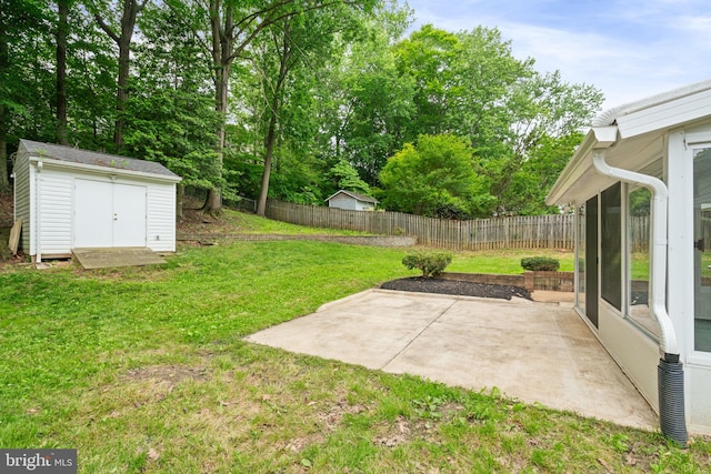 view of yard featuring a patio, a storage unit, and an outbuilding