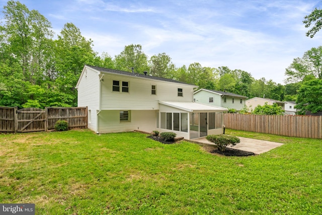 back of property with a sunroom, a patio area, a gate, and view of scattered trees