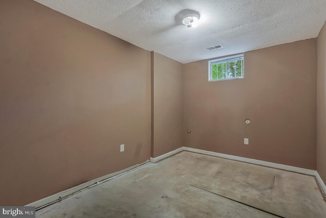 basement with baseboards and a textured ceiling