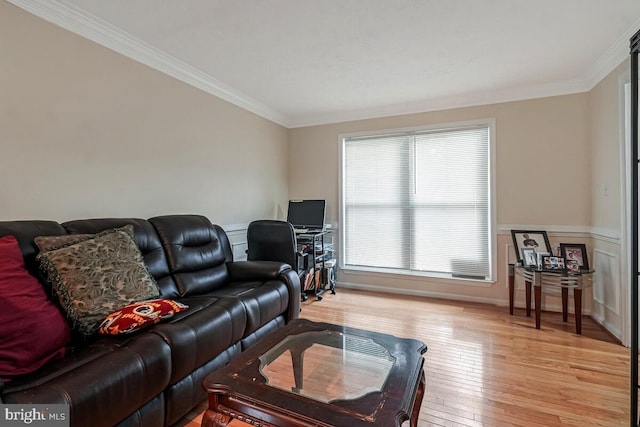 living area with ornamental molding, light wood finished floors, a wainscoted wall, and an office area