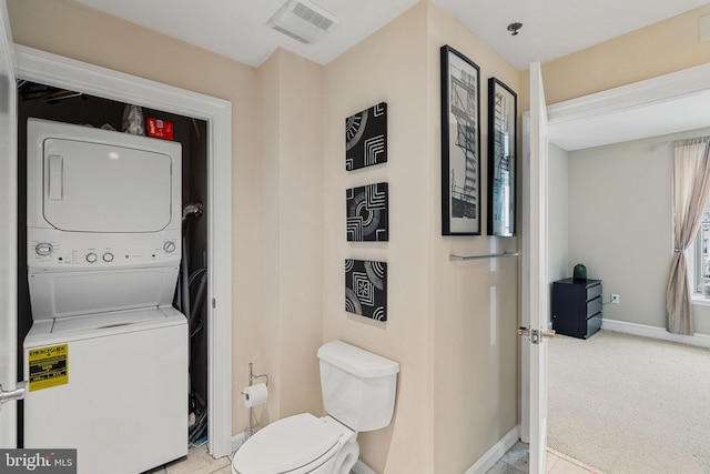 1811 Chestnut St Unit 405, Philadelphia, PA 19103 - bathroom with stacked washer and clothes dryer, toilet, and baseboards