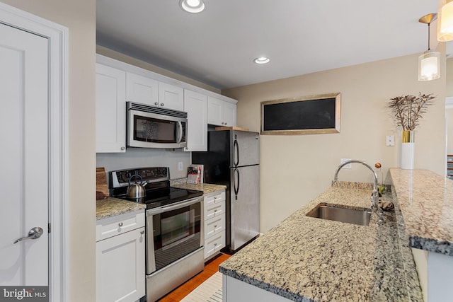 1811 Chestnut St Unit 405, Philadelphia, PA 19103 - kitchen with appliances with stainless steel finishes, a sink, white cabinetry, recessed lighting, and light stone counters