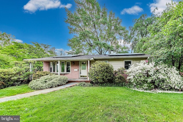 4951 Roslyn Rd, Annandale, VA 22003 - ranch-style home with brick siding, a front yard, roof mounted solar panels, and covered porch