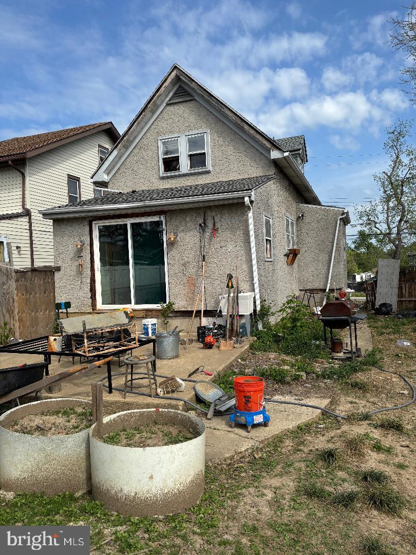 back of house featuring stucco siding and fence