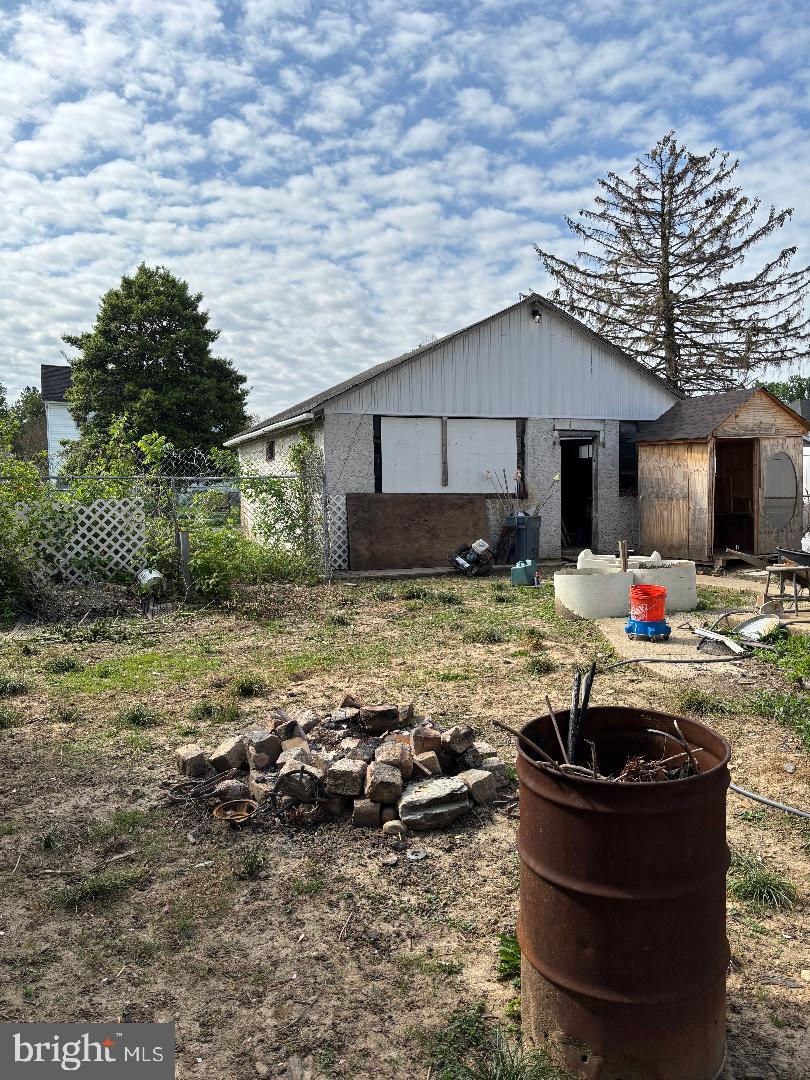 back of house with fence, a storage shed, and an outbuilding