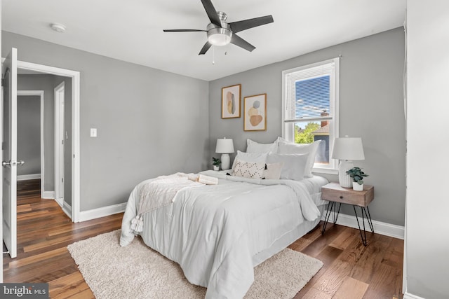 bedroom featuring baseboards, wood finished floors, and ceiling fan