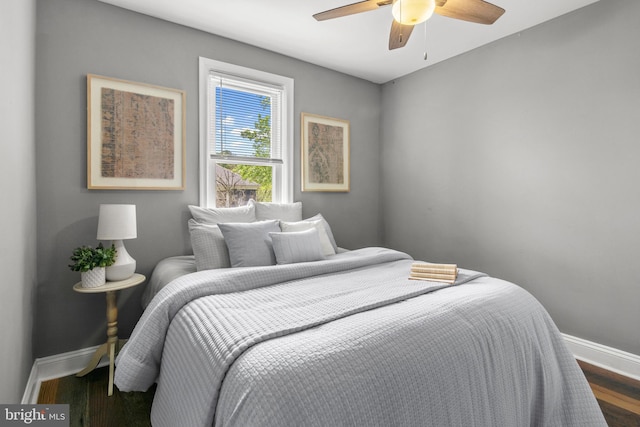 bedroom with baseboards, wood finished floors, and a ceiling fan