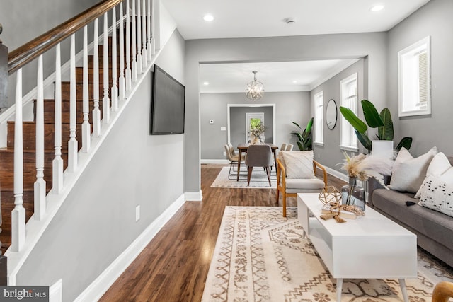 living room featuring wood finished floors, stairway, baseboards, recessed lighting, and a chandelier