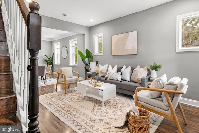 living room featuring baseboards, stairs, wood finished floors, recessed lighting, and ornamental molding