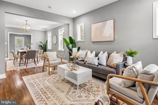 living area featuring baseboards, dark wood-style floors, a chandelier, recessed lighting, and crown molding