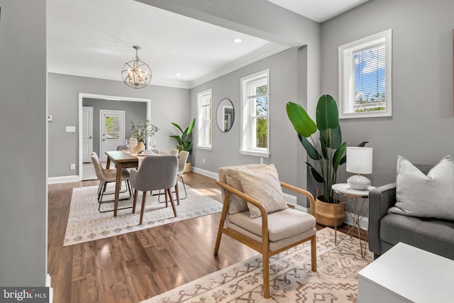 living room featuring a chandelier, baseboards, wood finished floors, crown molding, and recessed lighting