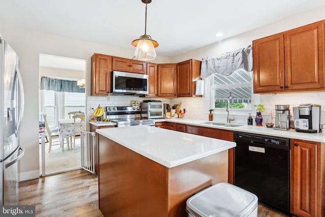 kitchen featuring appliances with stainless steel finishes, a sink, light countertops, tasteful backsplash, and recessed lighting