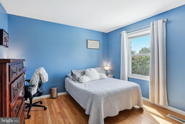 bedroom with light wood-type flooring and baseboards