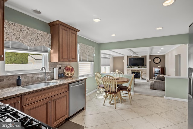 kitchen with dishwasher, a sink, a glass covered fireplace, recessed lighting, and ceiling fan