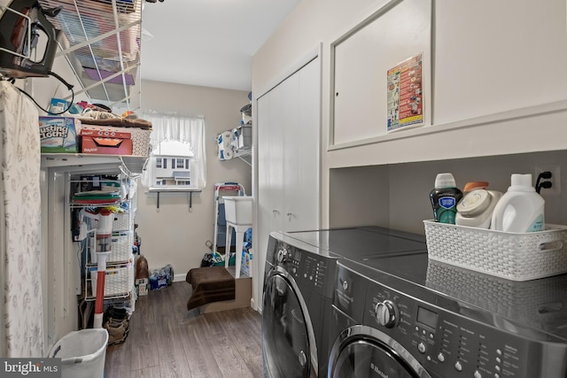 laundry room featuring cabinet space, washing machine and clothes dryer, wood finished floors, and baseboards