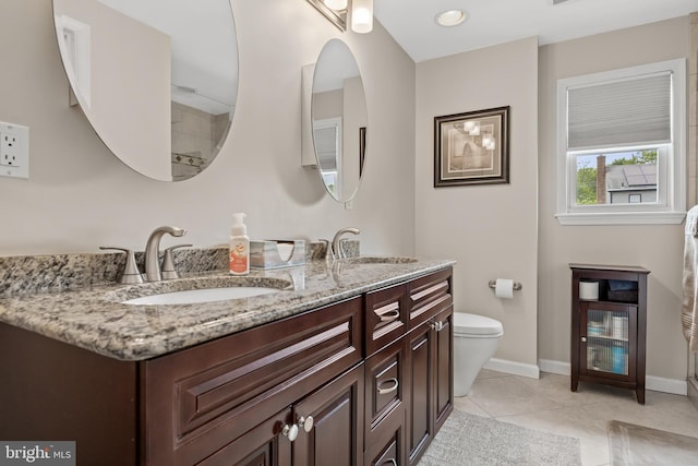 full bathroom featuring double vanity, baseboards, tile patterned floors, and toilet