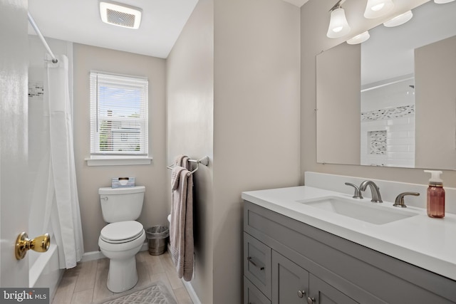 full bath featuring toilet, a shower with shower curtain, and vanity