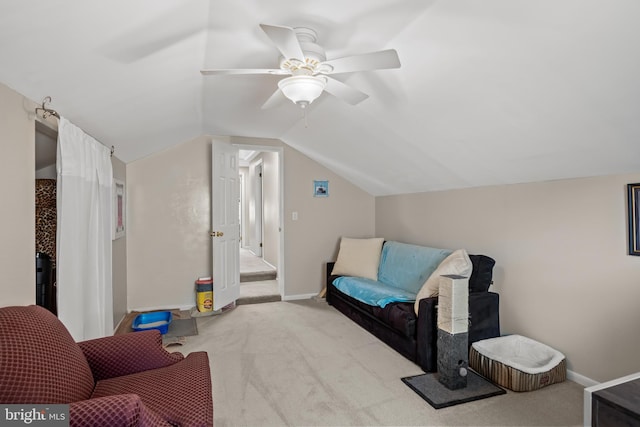 living area featuring carpet floors, vaulted ceiling, baseboards, and a ceiling fan