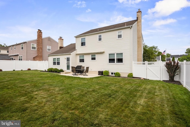 rear view of house with a patio, a chimney, and a gate