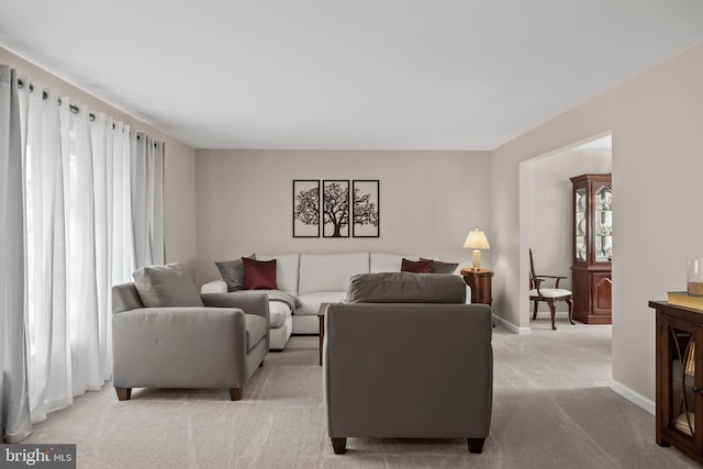 living room featuring light carpet and baseboards