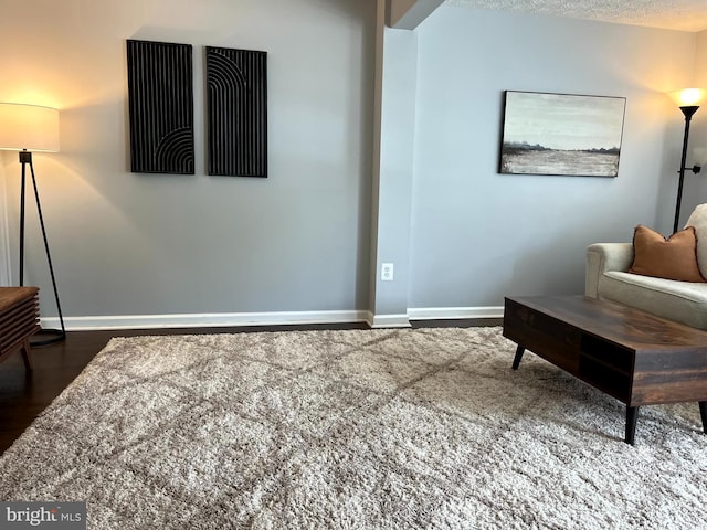 living area with baseboards and wood finished floors