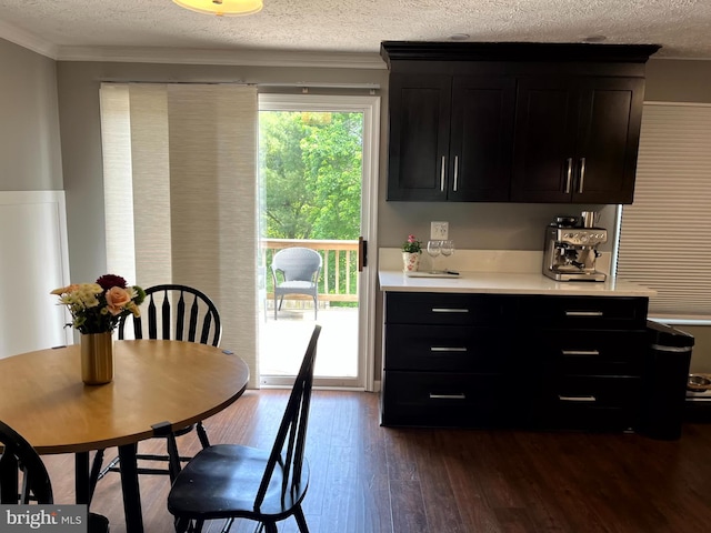 dining room featuring a textured ceiling, dark wood-style floors, and crown molding