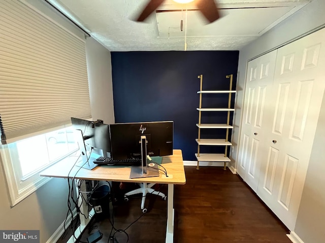 home office featuring attic access, ceiling fan, baseboards, and wood finished floors