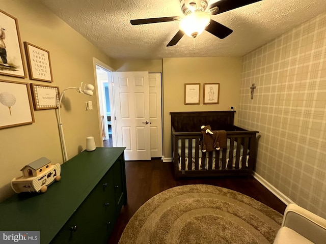 bedroom with a textured ceiling, wood finished floors, baseboards, and a ceiling fan