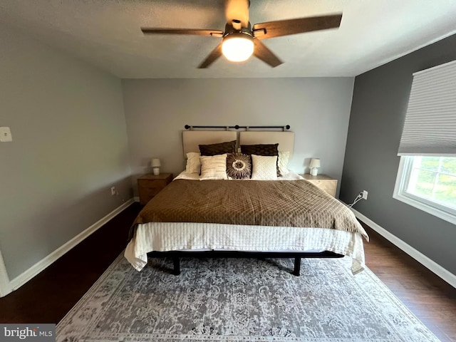 bedroom with wood finished floors, baseboards, and a ceiling fan