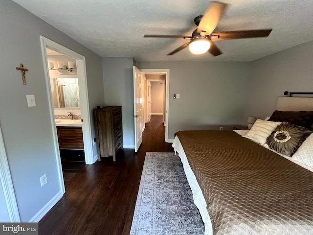 bedroom featuring wood finished floors, baseboards, a textured ceiling, a ceiling fan, and ensuite bathroom