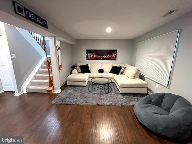 living area with wood finished floors, stairs, and baseboards