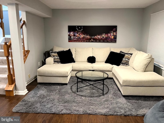 living area featuring wood finished floors, stairs, and baseboards