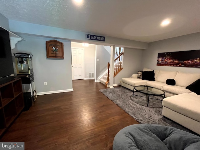 living area with baseboards, wood finished floors, and stairway