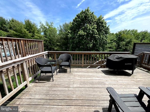 wooden deck featuring a grill