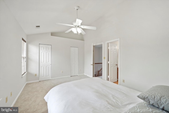 146 Connery Ter SW, Leesburg, VA 20175 - bedroom featuring two closets, light colored carpet, baseboards, high vaulted ceiling, and a ceiling fan