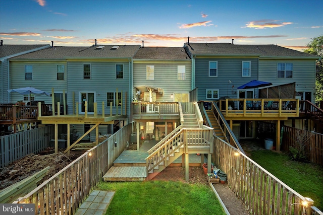 146 Connery Ter SW, Leesburg, VA 20175 - back of house at dusk with stairway, a deck, and roof with shingles