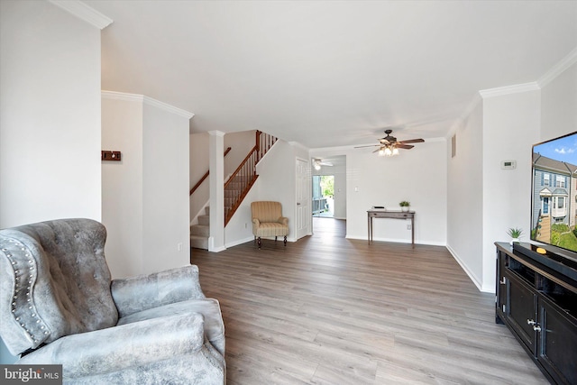 146 Connery Ter SW, Leesburg, VA 20175 - living area with stairs, light wood finished floors, a ceiling fan, crown molding, and baseboards