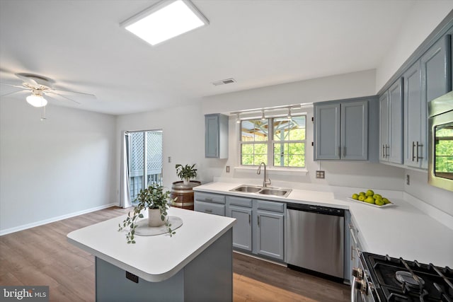 146 Connery Ter SW, Leesburg, VA 20175 - kitchen featuring appliances with stainless steel finishes, a sink, gray cabinetry, light countertops, and a kitchen island