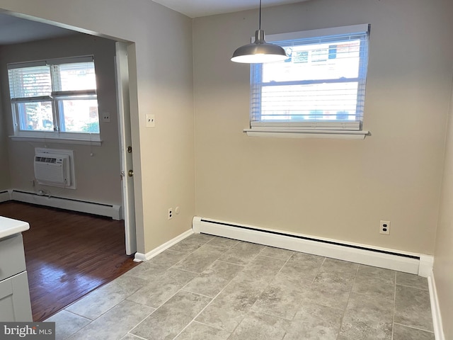 unfurnished dining area with a baseboard radiator, a wall unit AC, and healthy amount of natural light