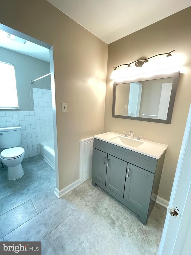 bathroom with vanity, toilet, washtub / shower combination, tile walls, and tile patterned flooring